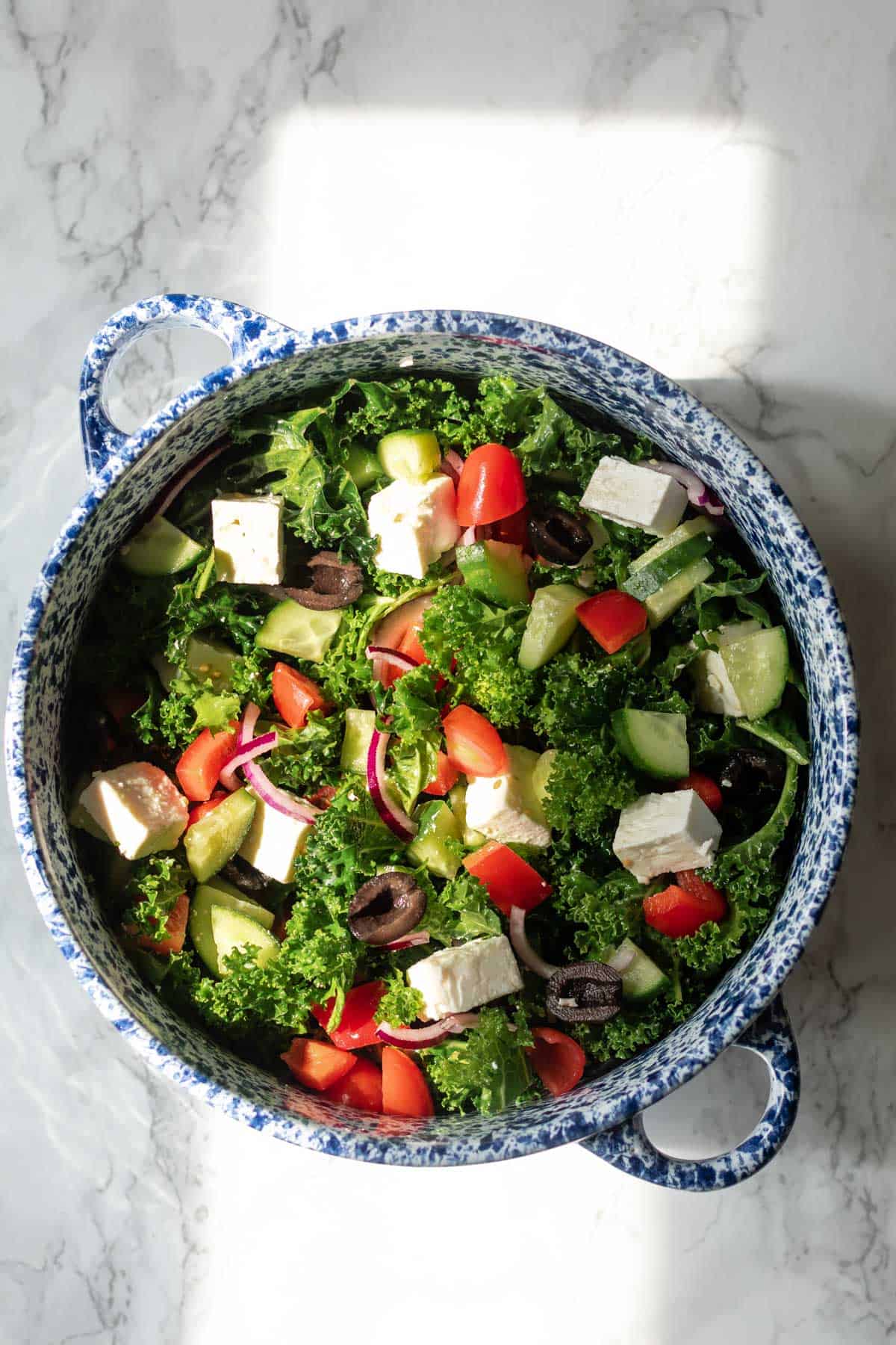 a bowl of mixed kale greek salad
