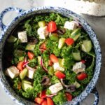 a large bowl of greek salad with kale