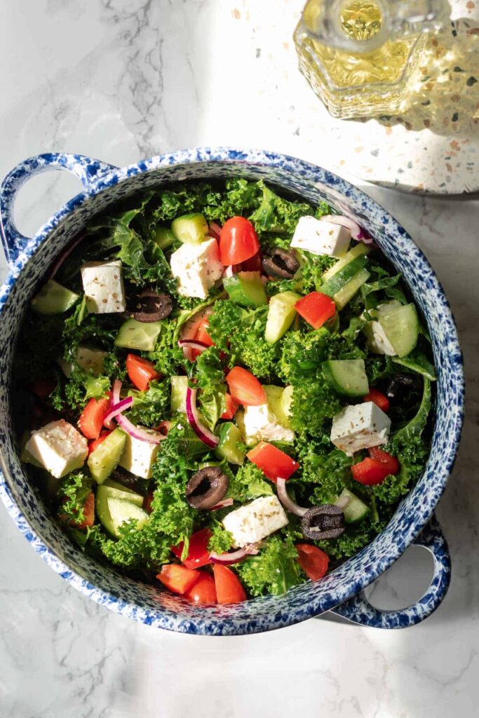 a large bowl of greek salad with kale