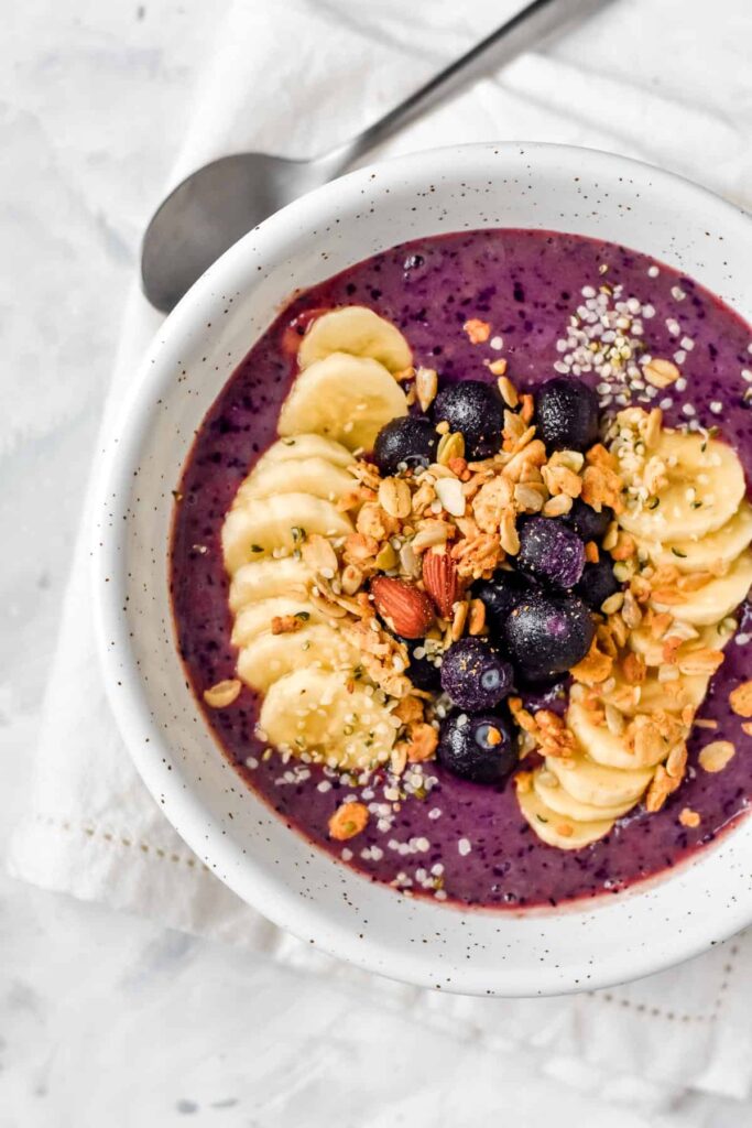 a smoothie bowl topped with banana and granola