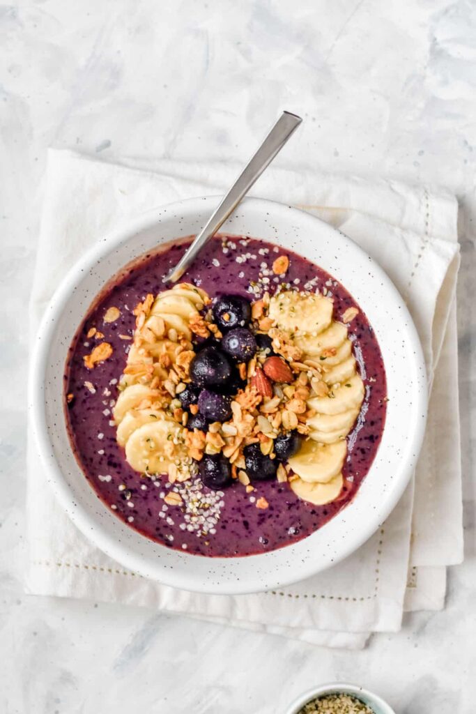 a bowl of smoothie topped with granola and berries