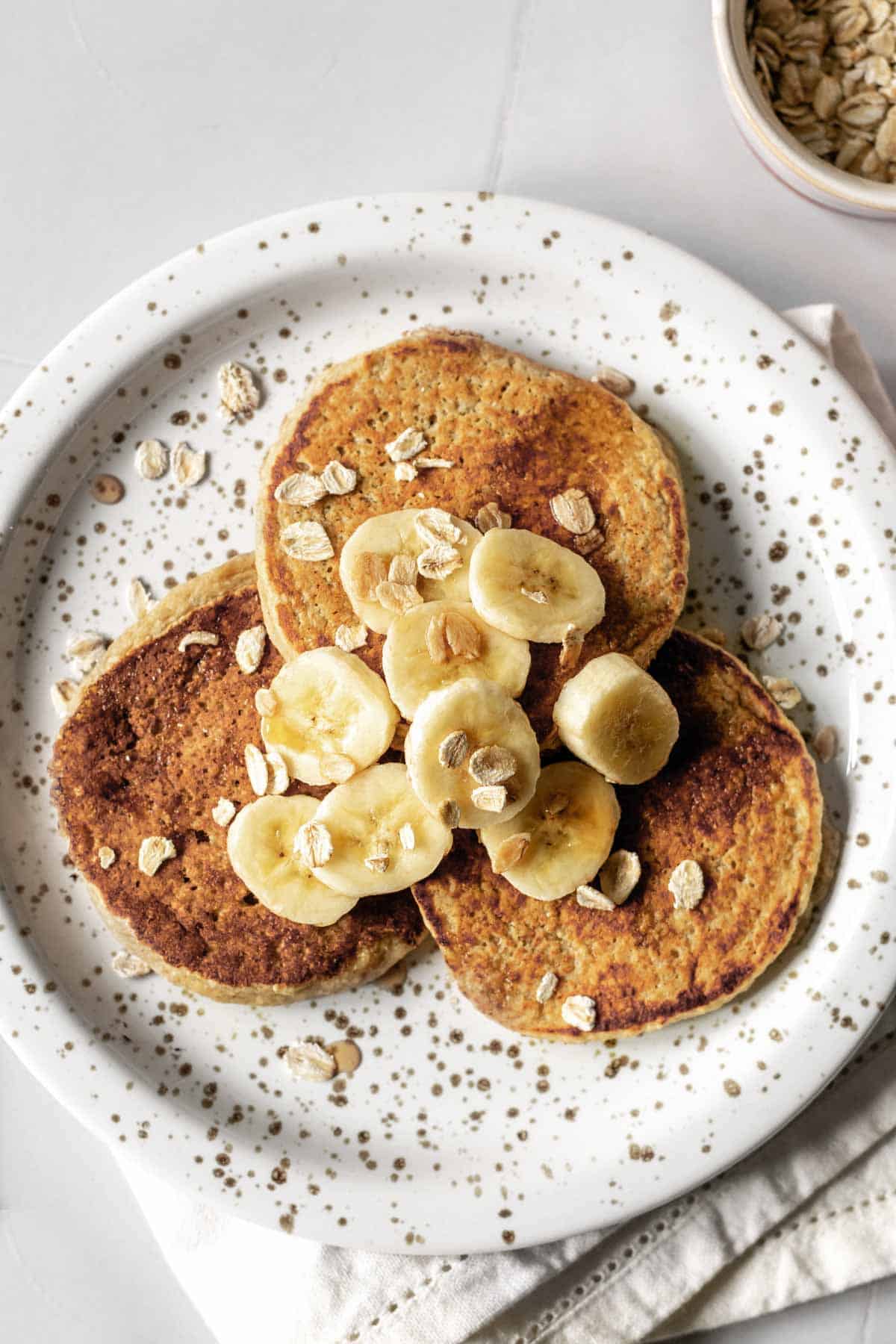 a plate of pancakes topped with bananas
