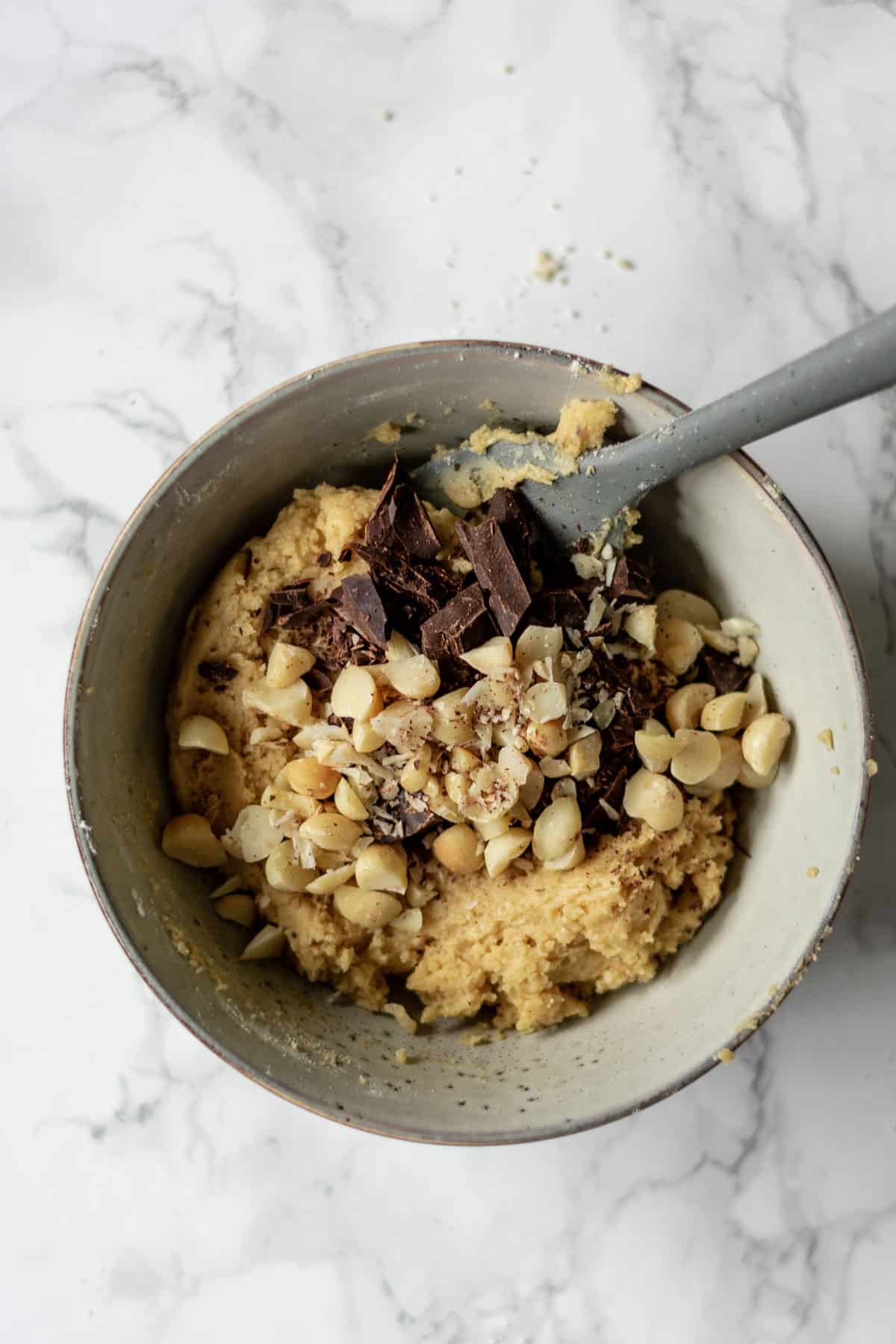 cookie dough topped with macadamia nuts and chopped chocolate