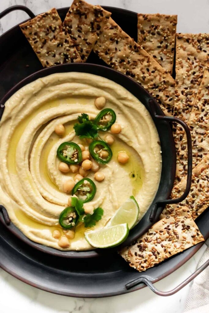 a bowl of hummus and some crackers