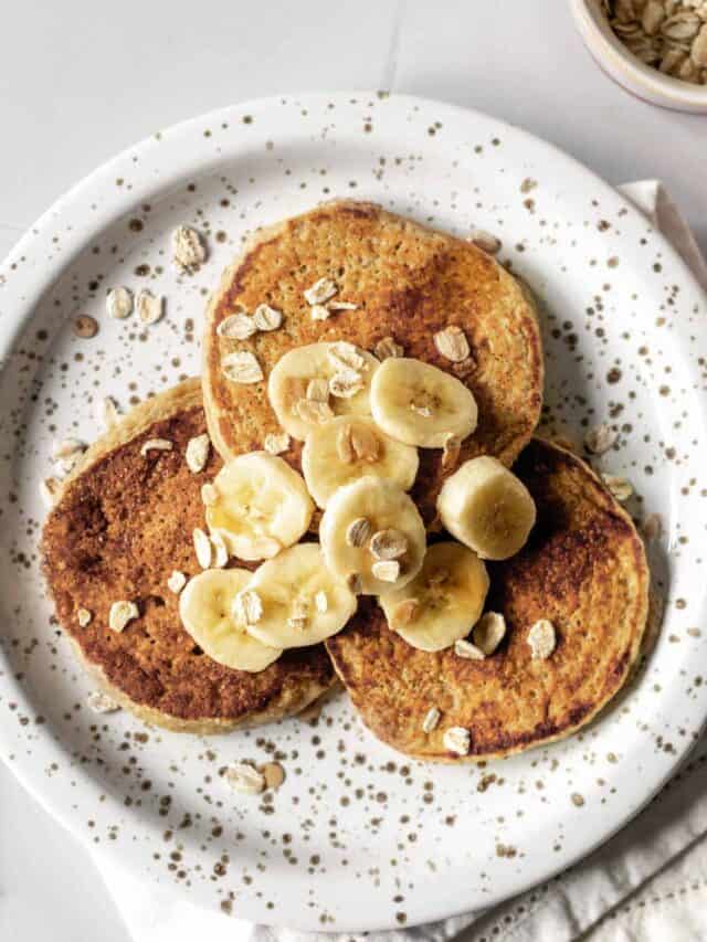 a plate of pancakes topped with bananas