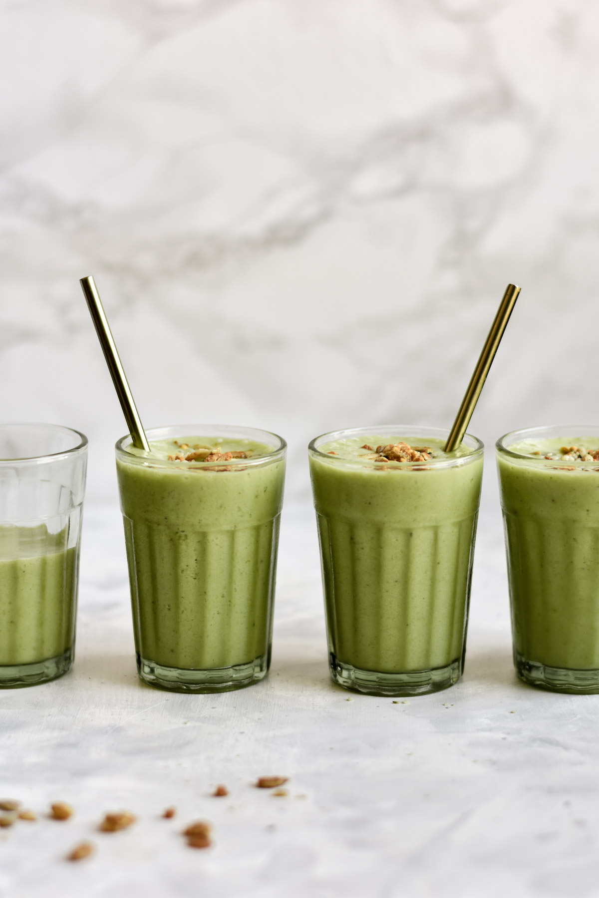 four glasses of green smoothies
