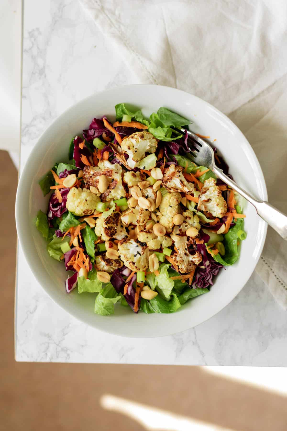 a bowl of roasted cauliflower salad with a fork