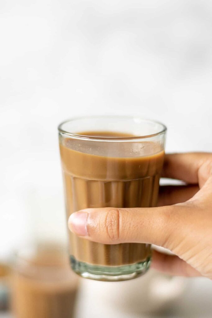 a cup of masala chai being held up