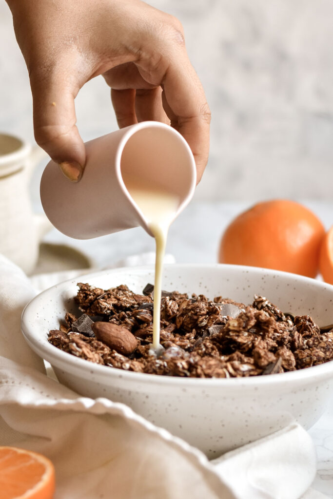 milk being poured into a bowl of granola