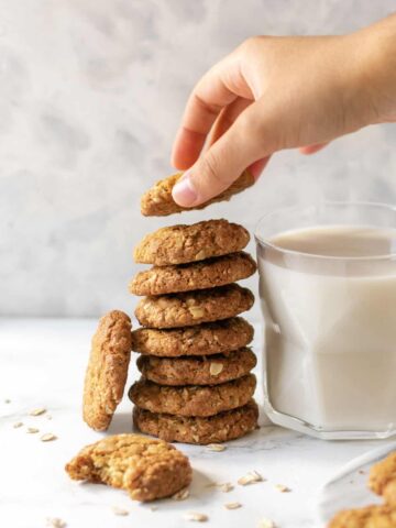 a stack of cookies next to a glass of milk