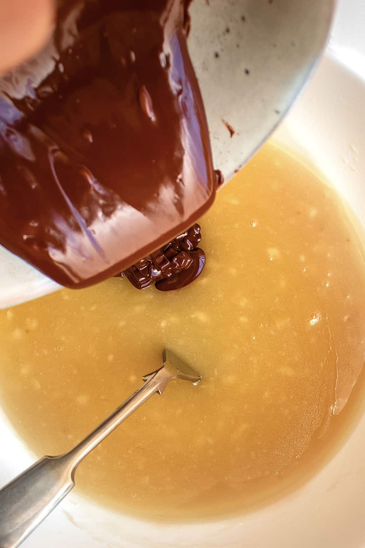chocolate being poured into brownie batter