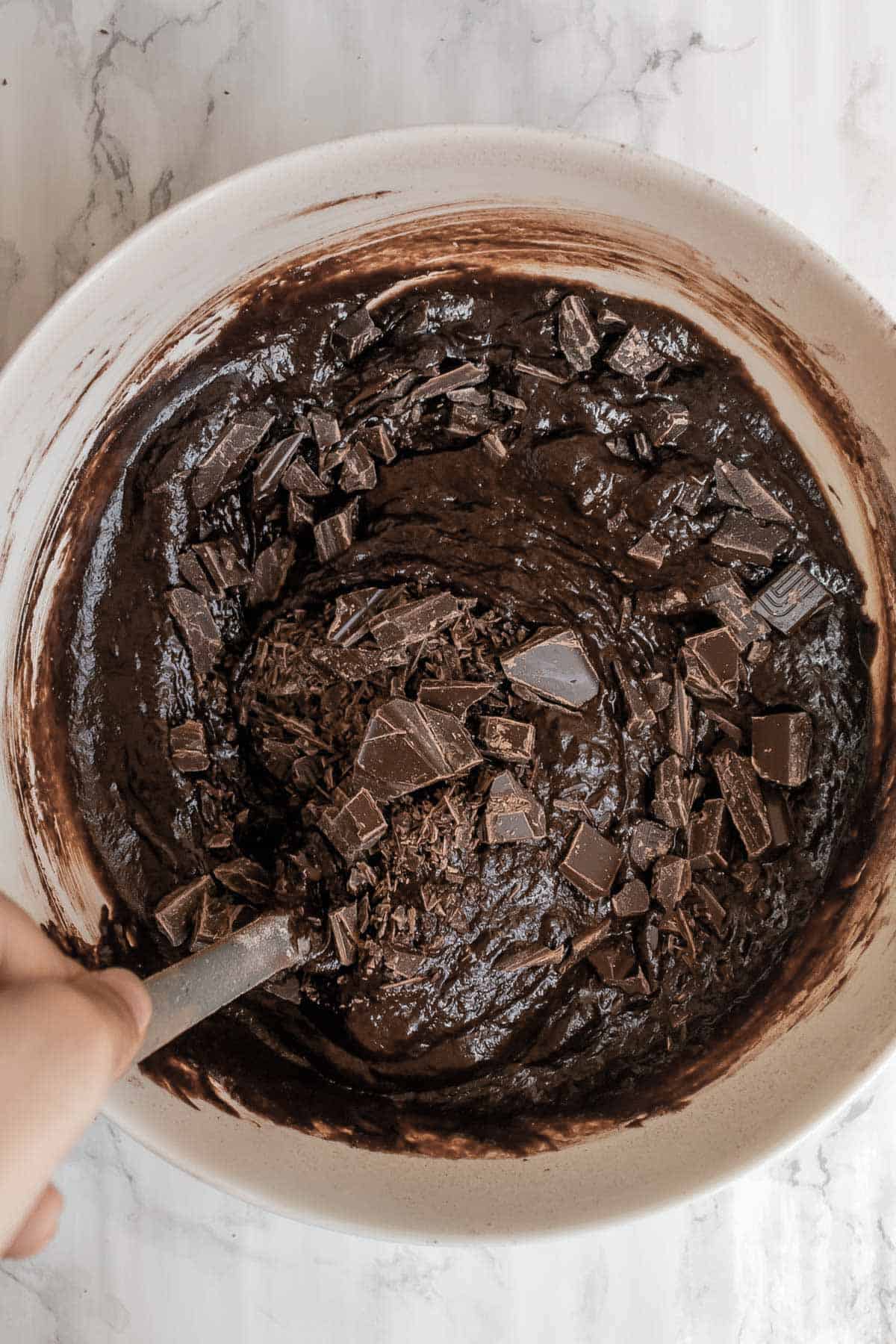 chocolate being stirred into brownie batter