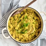 a pot of yellow rice with a spoon