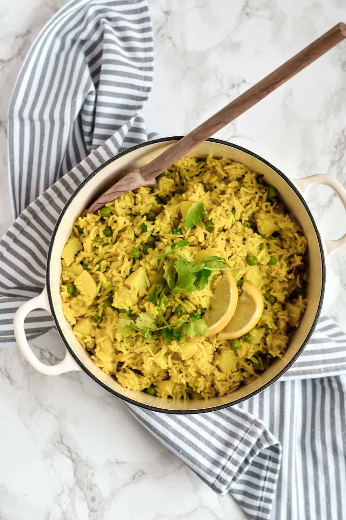 a pot of yellow rice with a spoon