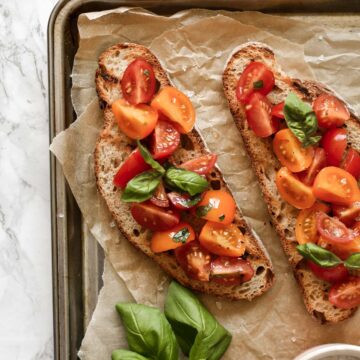 two slices of bruschetta topped with basil