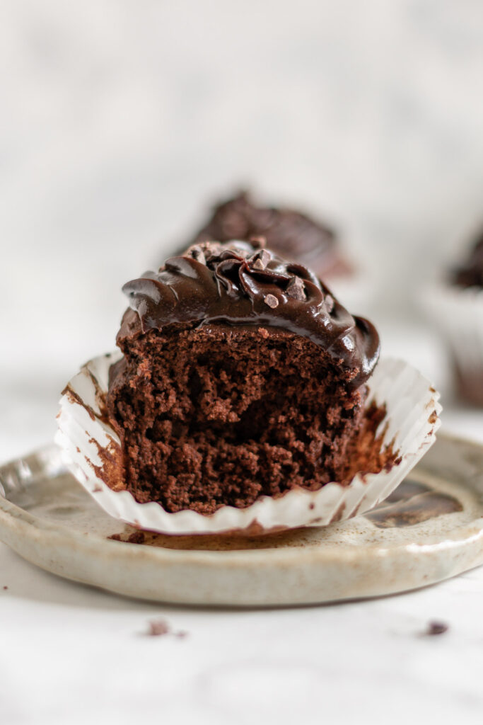 a chocolate cupcake with a bite taken from it
