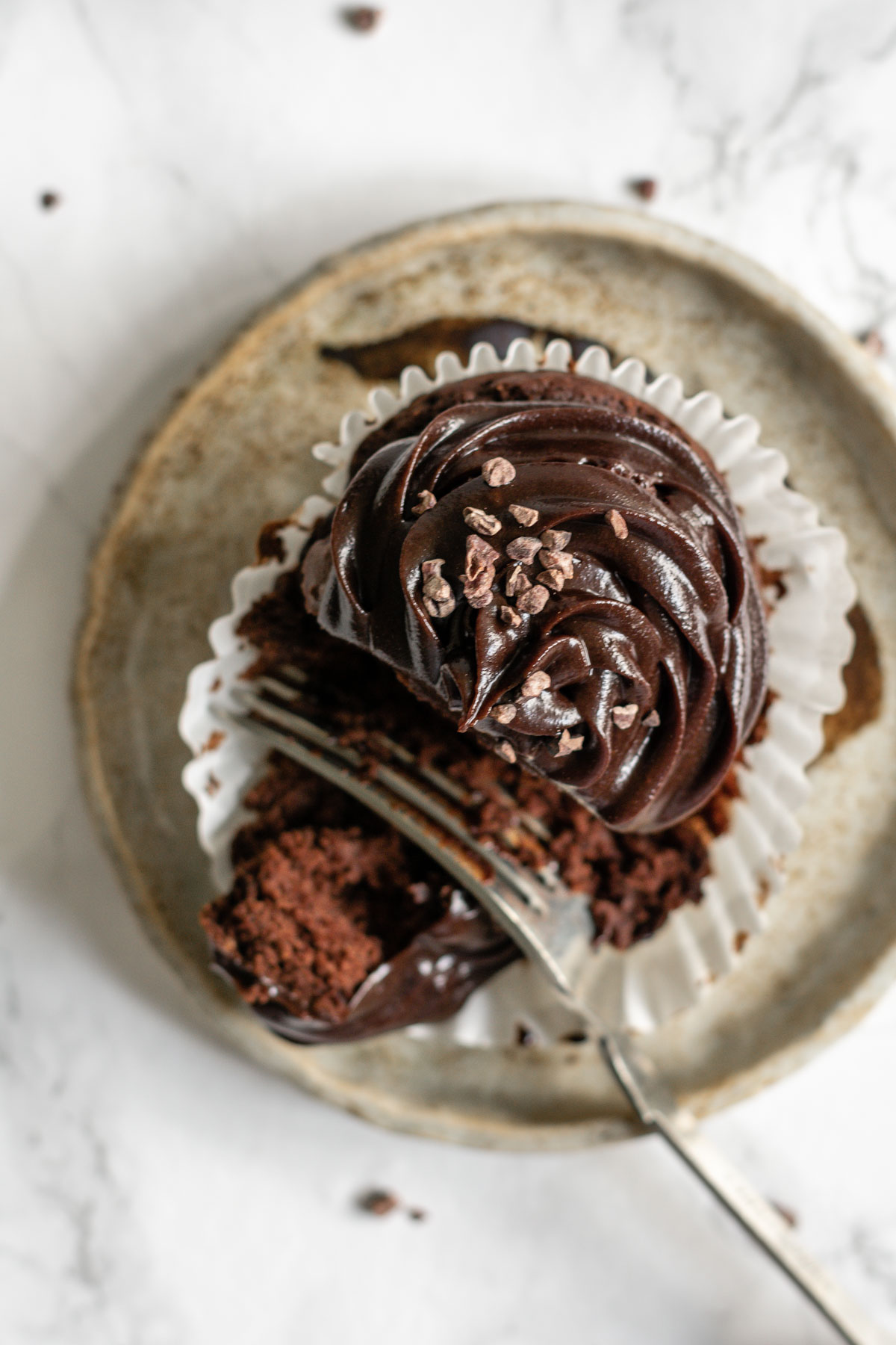 a chocolate cupcake being dug into with a fork