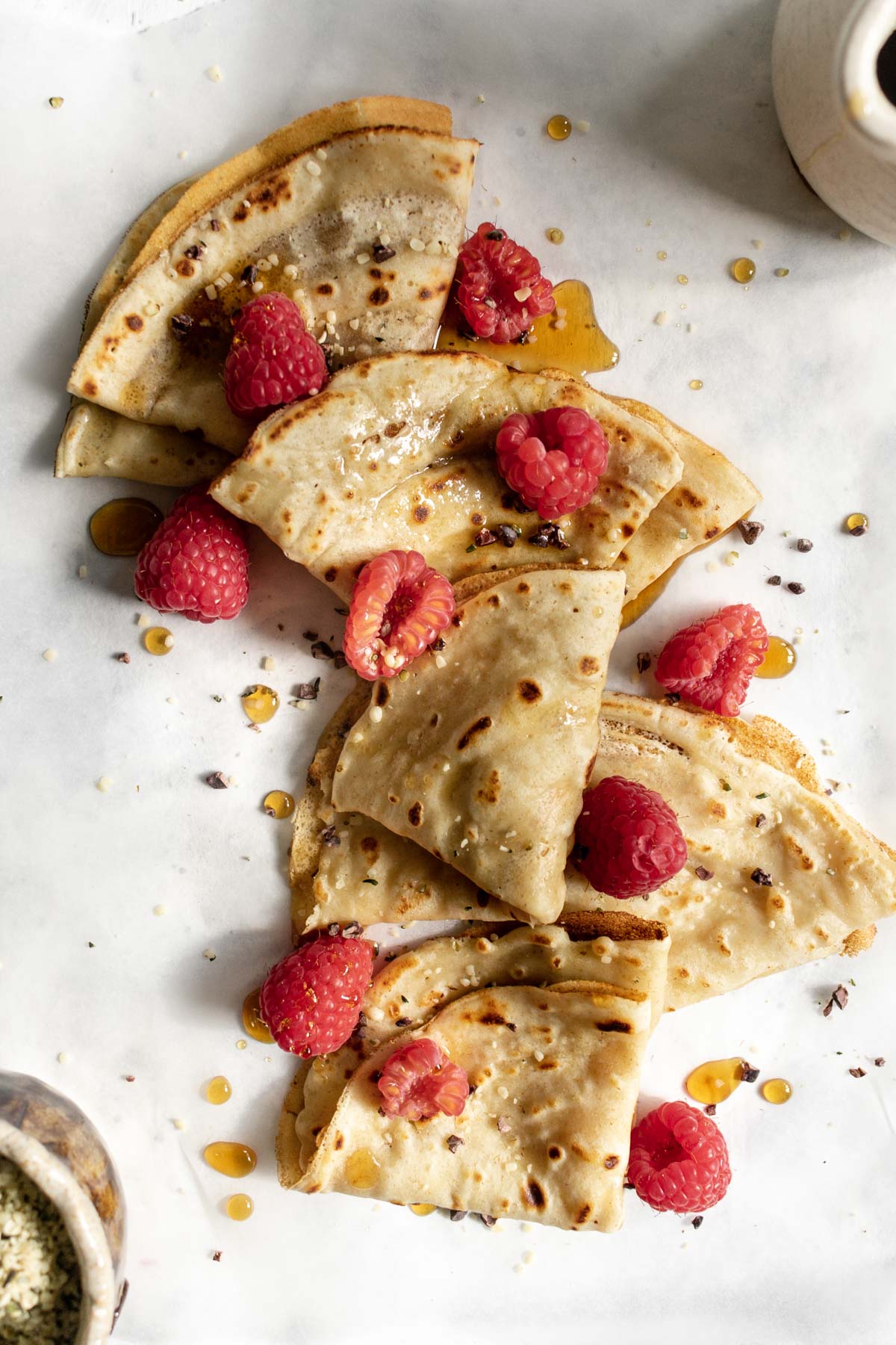 crepes topped with raspberries and maple syrup