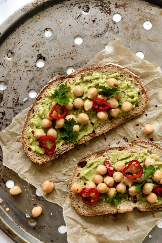 avocado toast topped with sliced chilli and chickpeas