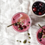 two glasses of smoothie topped with fruit