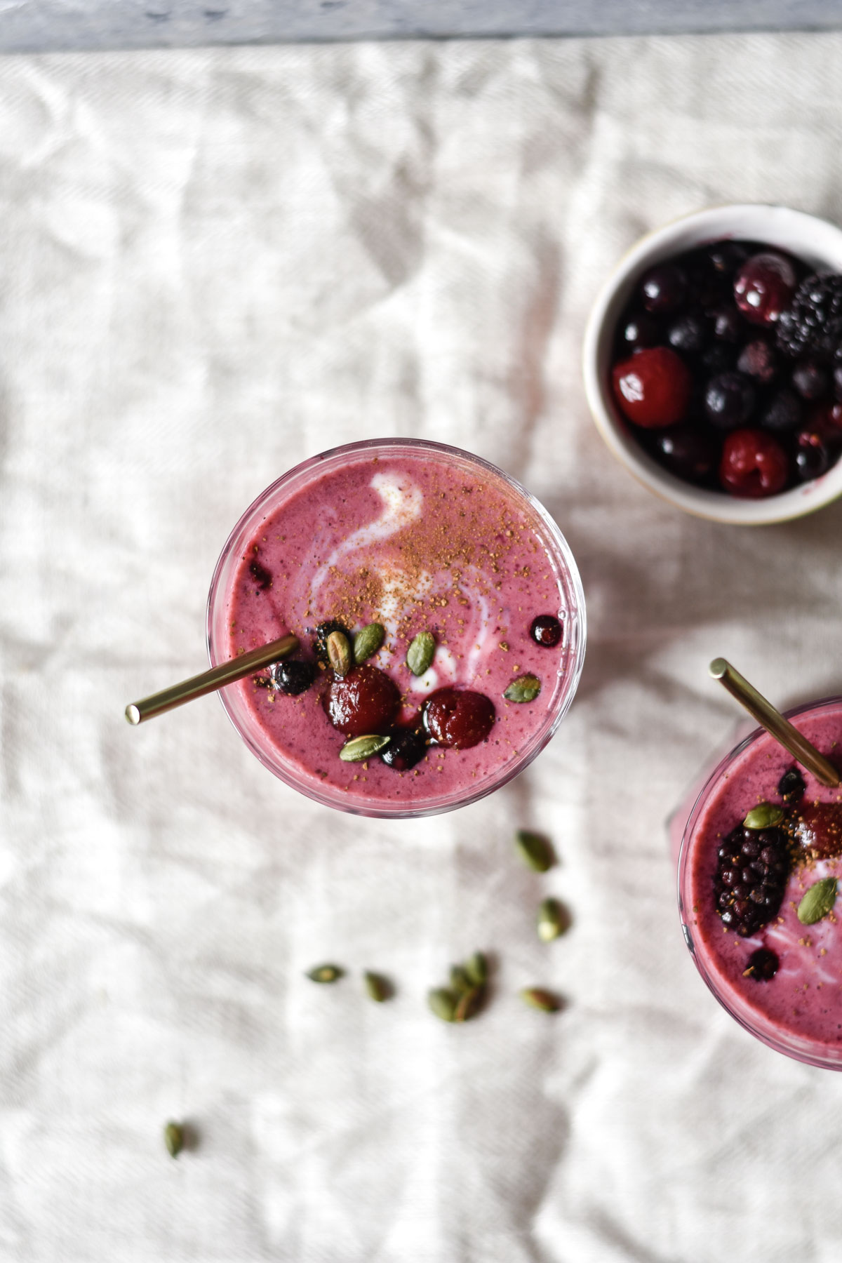 two glasses of smoothie topped with fruit