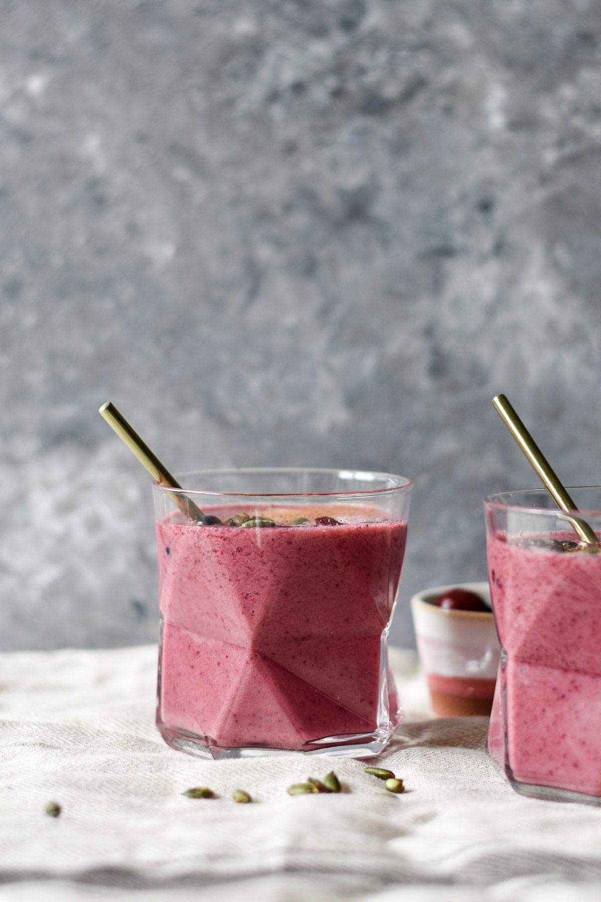two geometrical glasses filled with pink smoothie