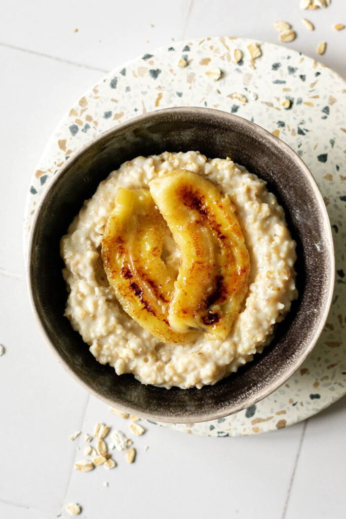 a bowl of creamy oatmeal topped with caramelised bananas