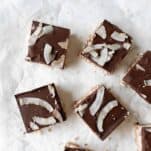 some squares of coconut bars topped with chocolate