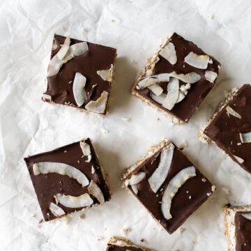 some squares of coconut bars topped with chocolate