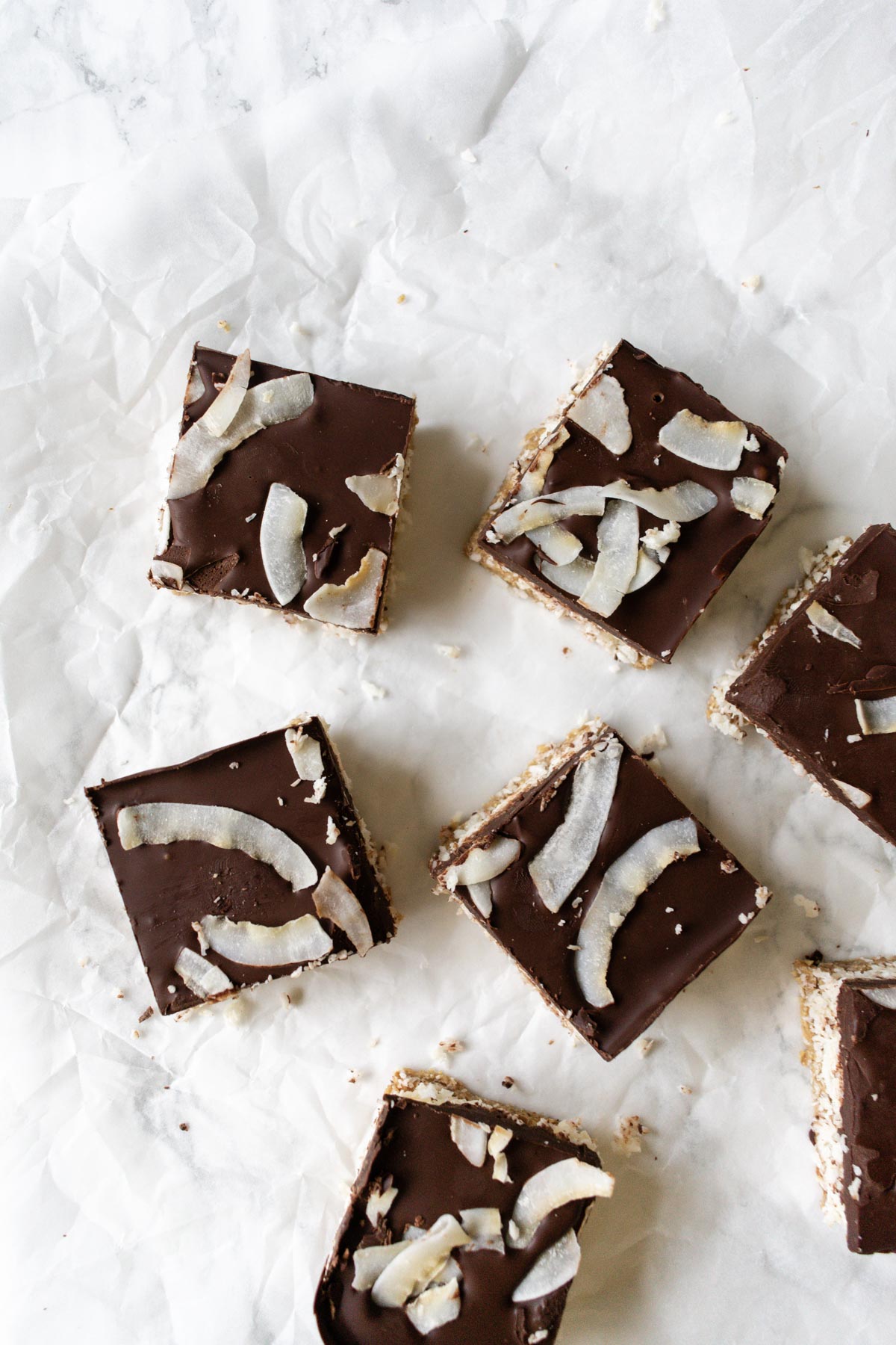 some squares of coconut bars topped with chocolate