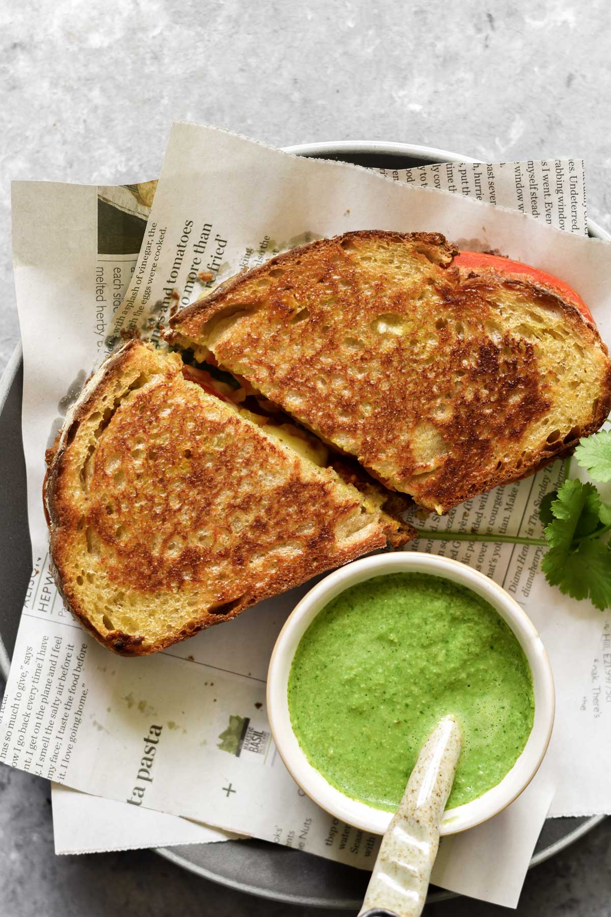 a bowl of chutney and two slices of grilled cheese