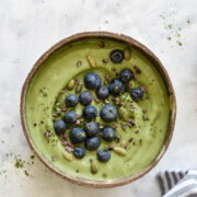 a green smoothie bowl topped with blueberries