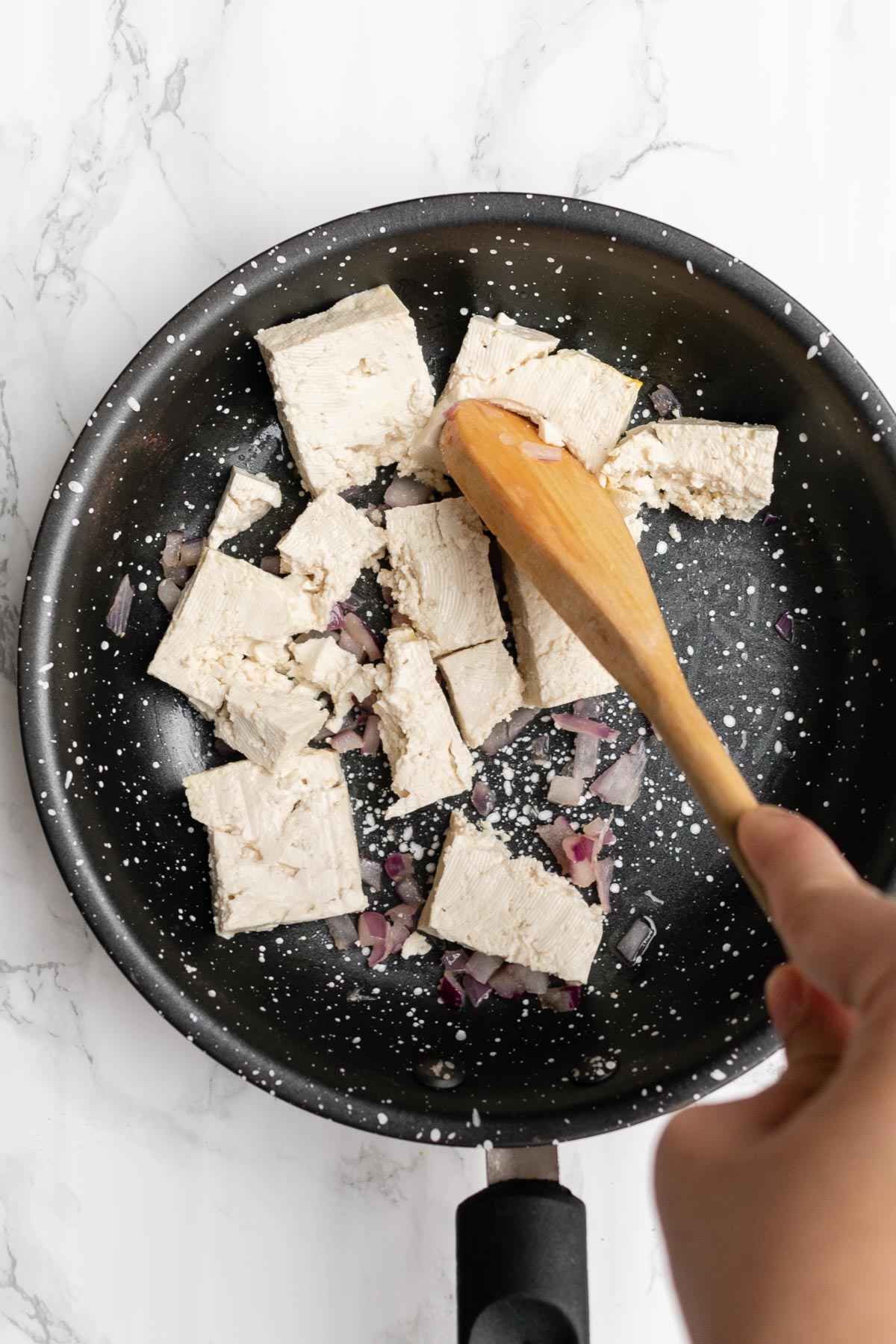 tofu being broken up in a pan