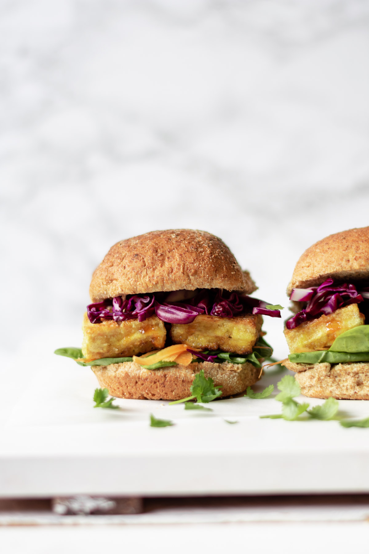 two tofu burgers on a board