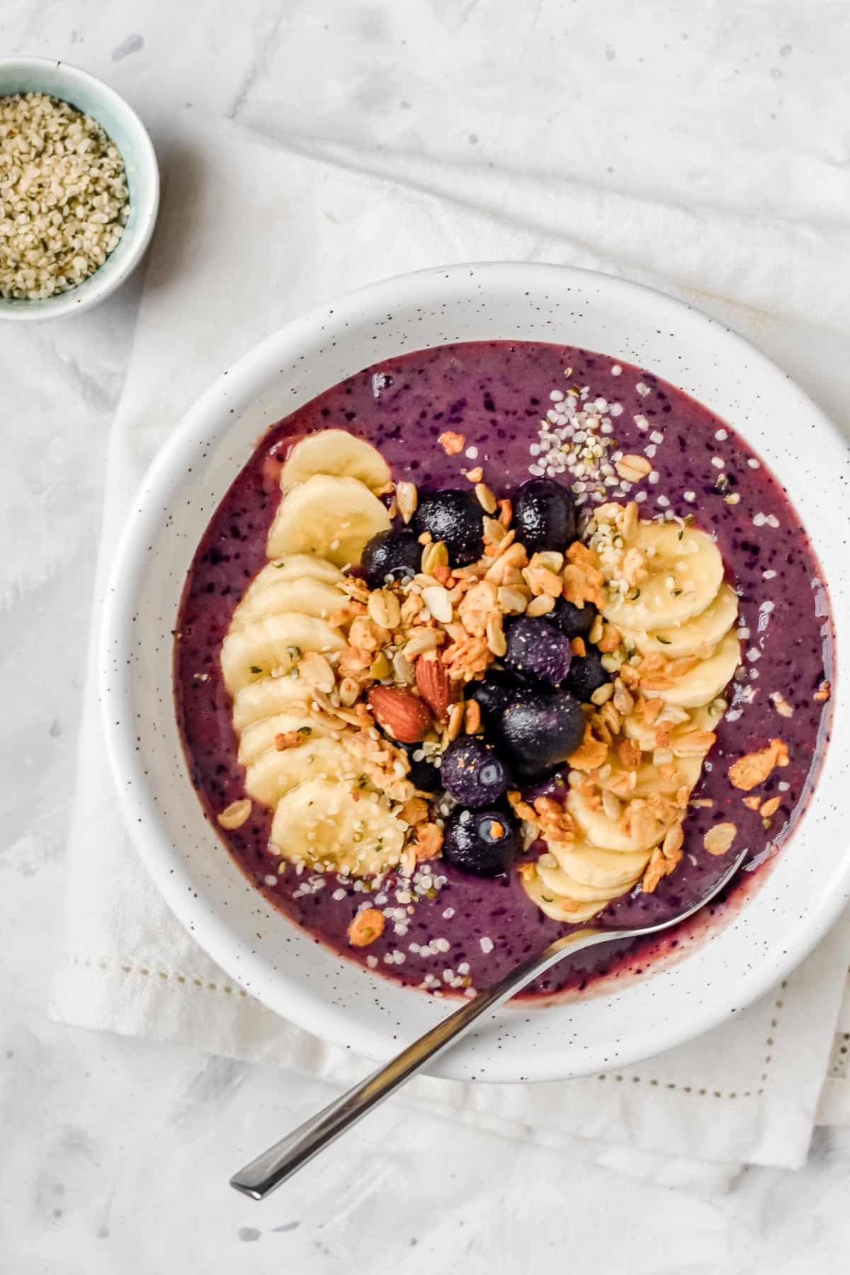 a blueberry smoothie bowl topped with granola and berries