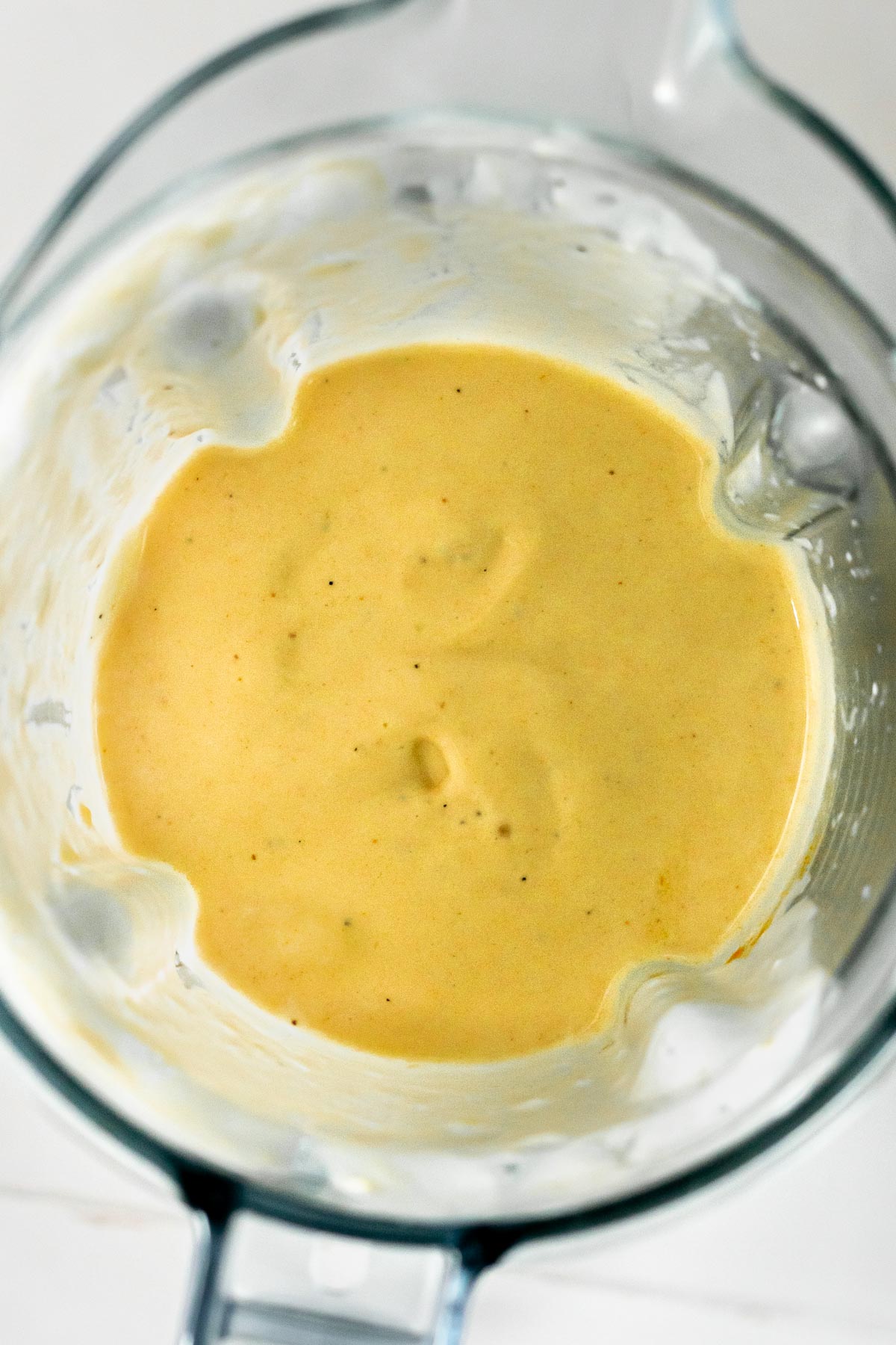 creamy blended mango lassi in a blender jug