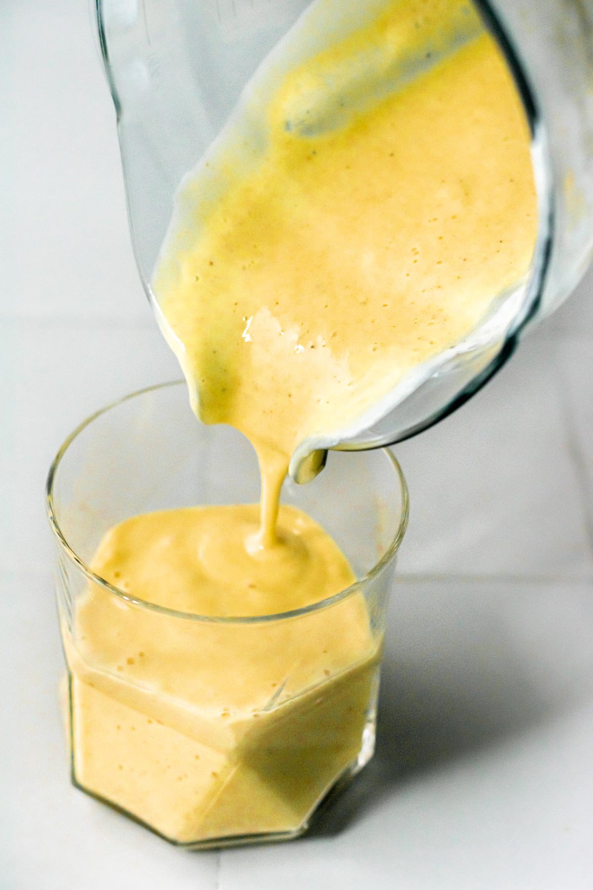 mango lassi being poured into a geometric glass