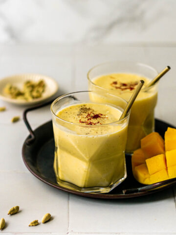 two glasses of mango lassi on a tray