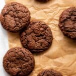 some chocolate brownie cookies on a sheet of baking parchment