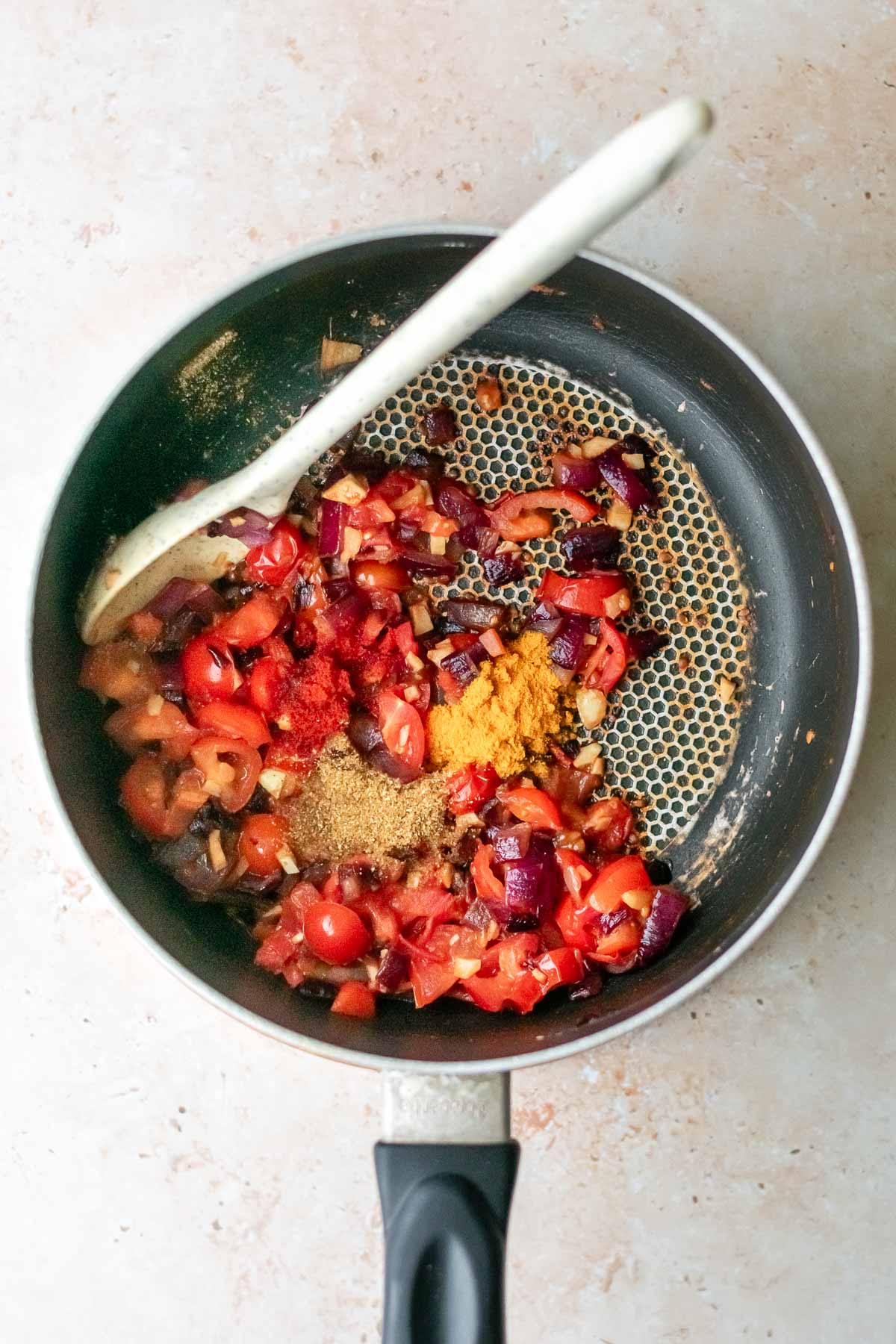 masala added to the ingredients for chickpea curry