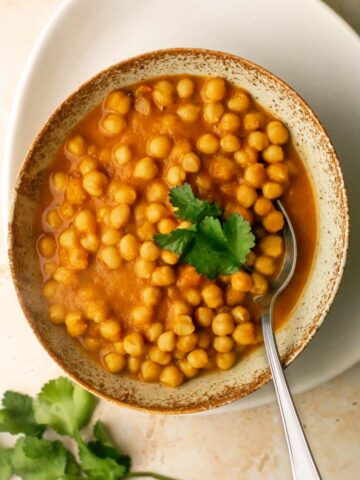 a bowl of chana masala curry with a spoon