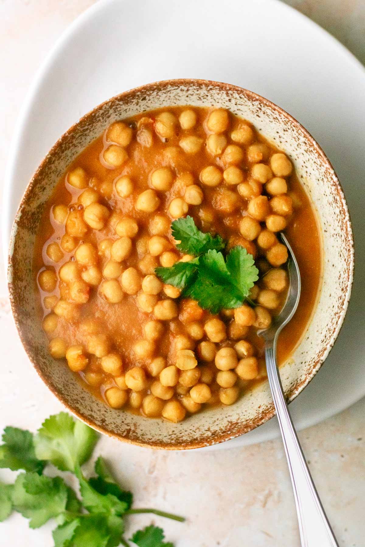 a bowl of chana masala curry with a spoon