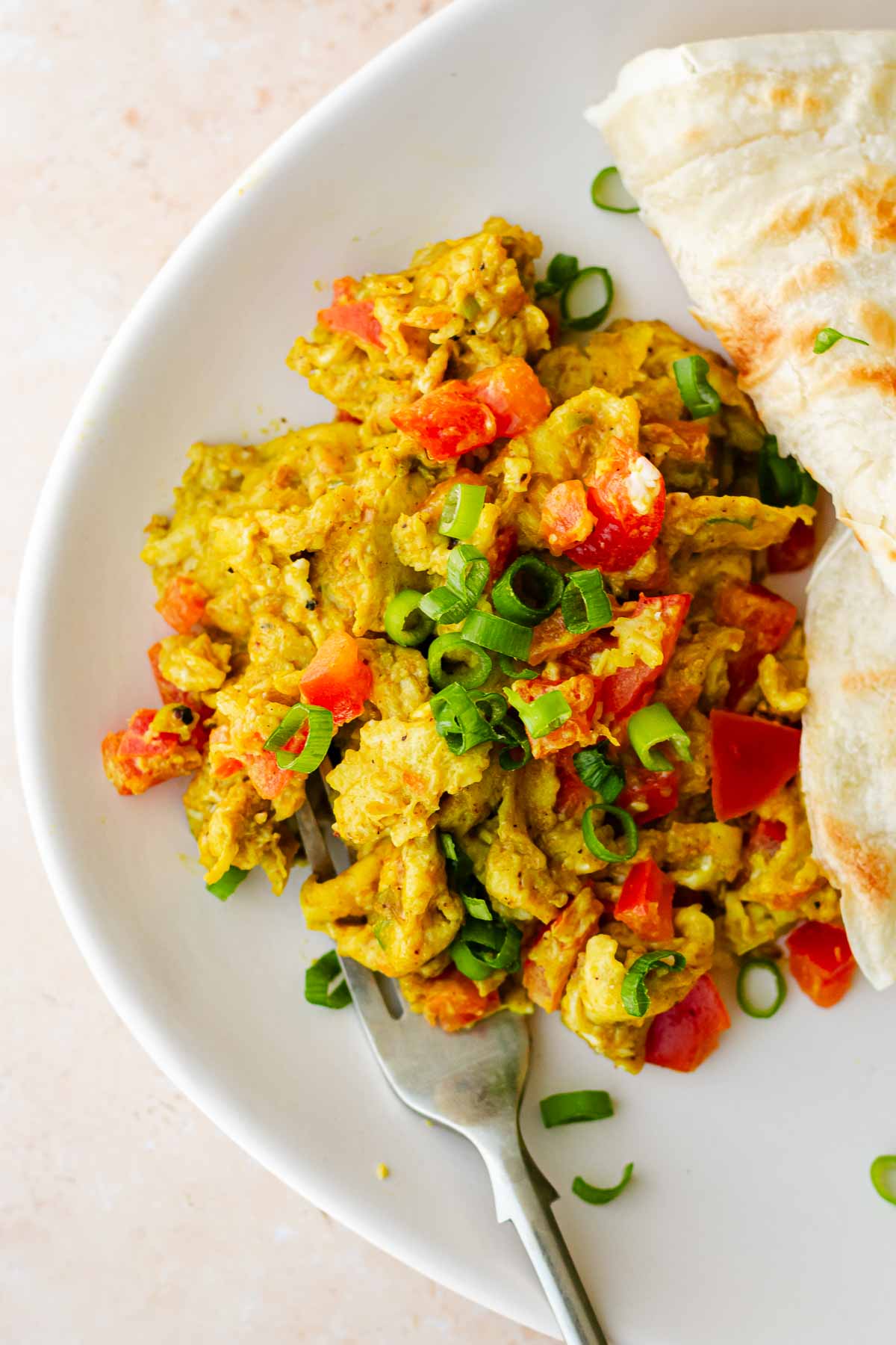 a plate of spicy scrambled eggs with a fork