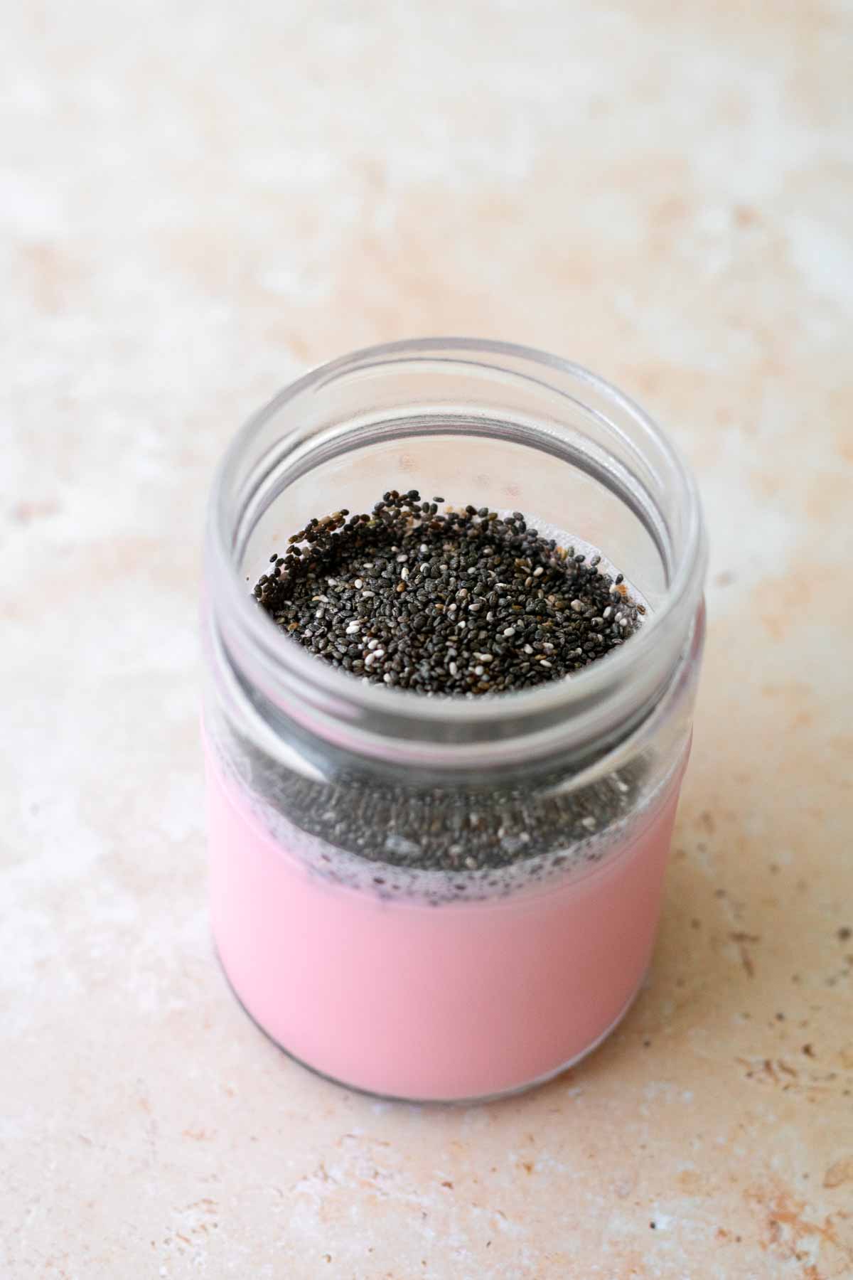 a jar with rose milk and chia seeds