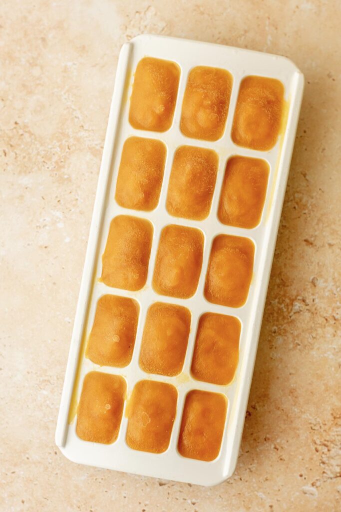 an ice cube tray filled with mango pulp