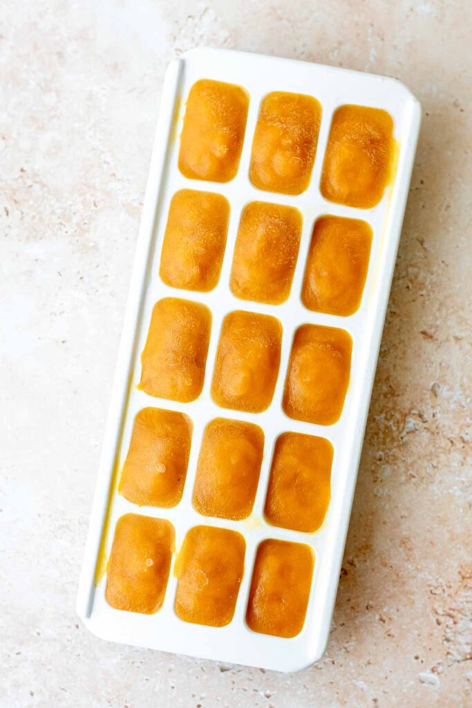 an ice cube tray filled with mango pulp