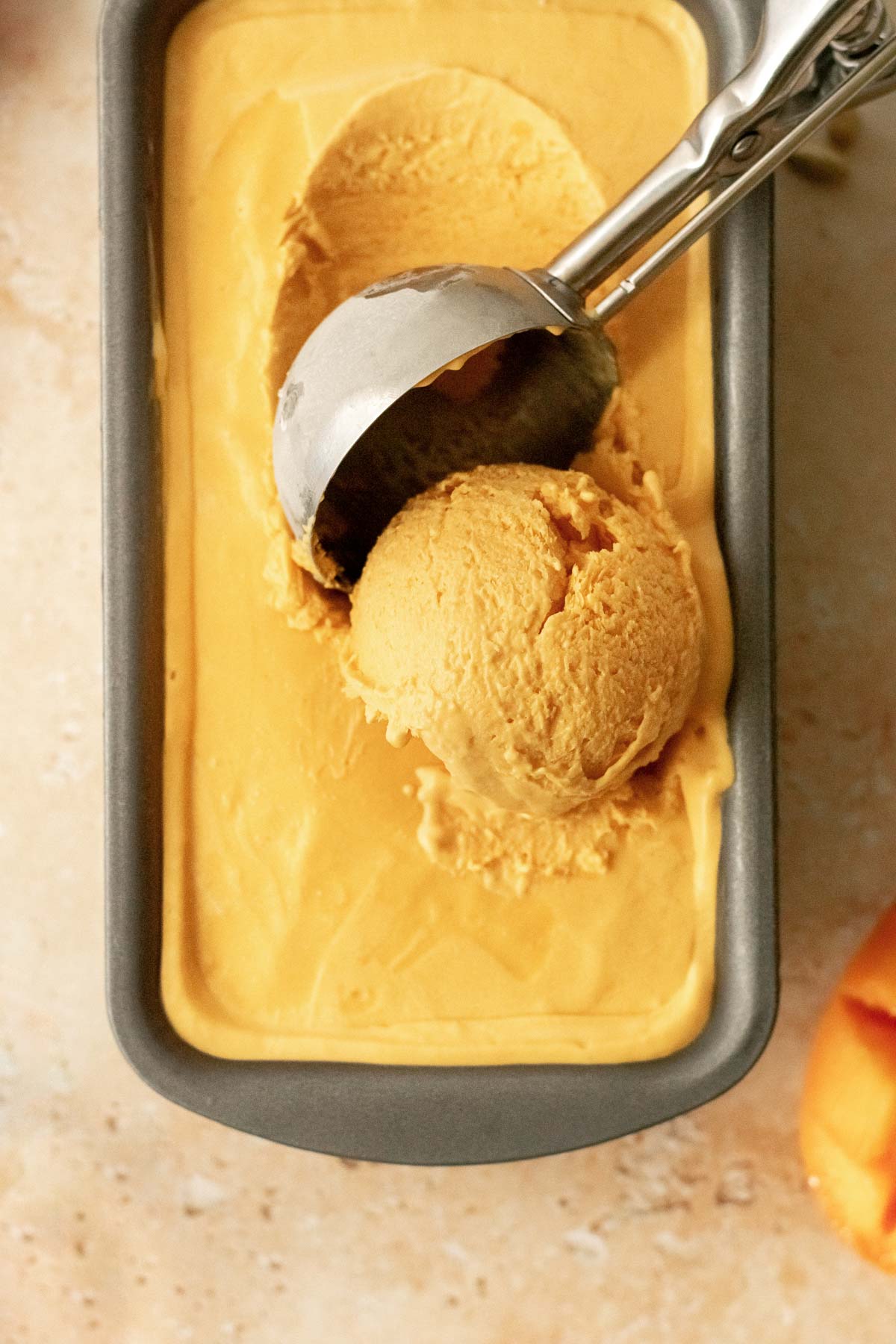 mango ice cream being scooped with an ice cream scoop