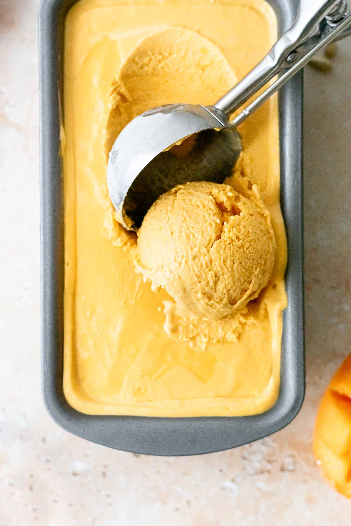 mango ice cream being scooped with an ice cream scoop