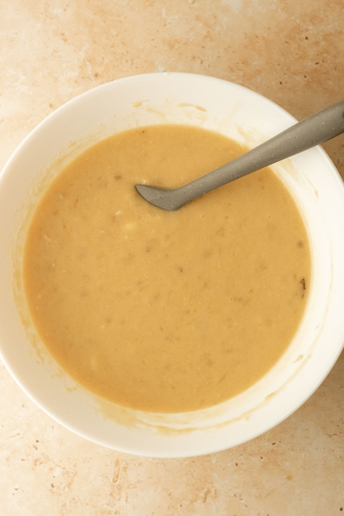 wet ingredients for banana bread mixed together in a bowl