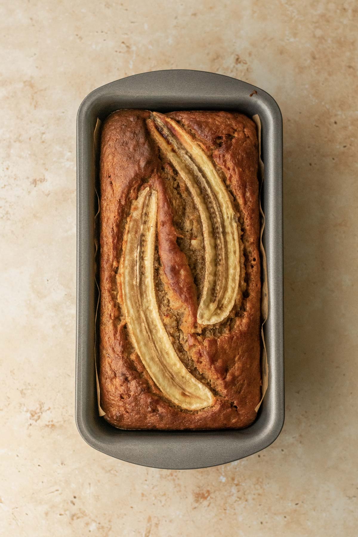 a loaf of freshly baked banana bread in the loaf tin